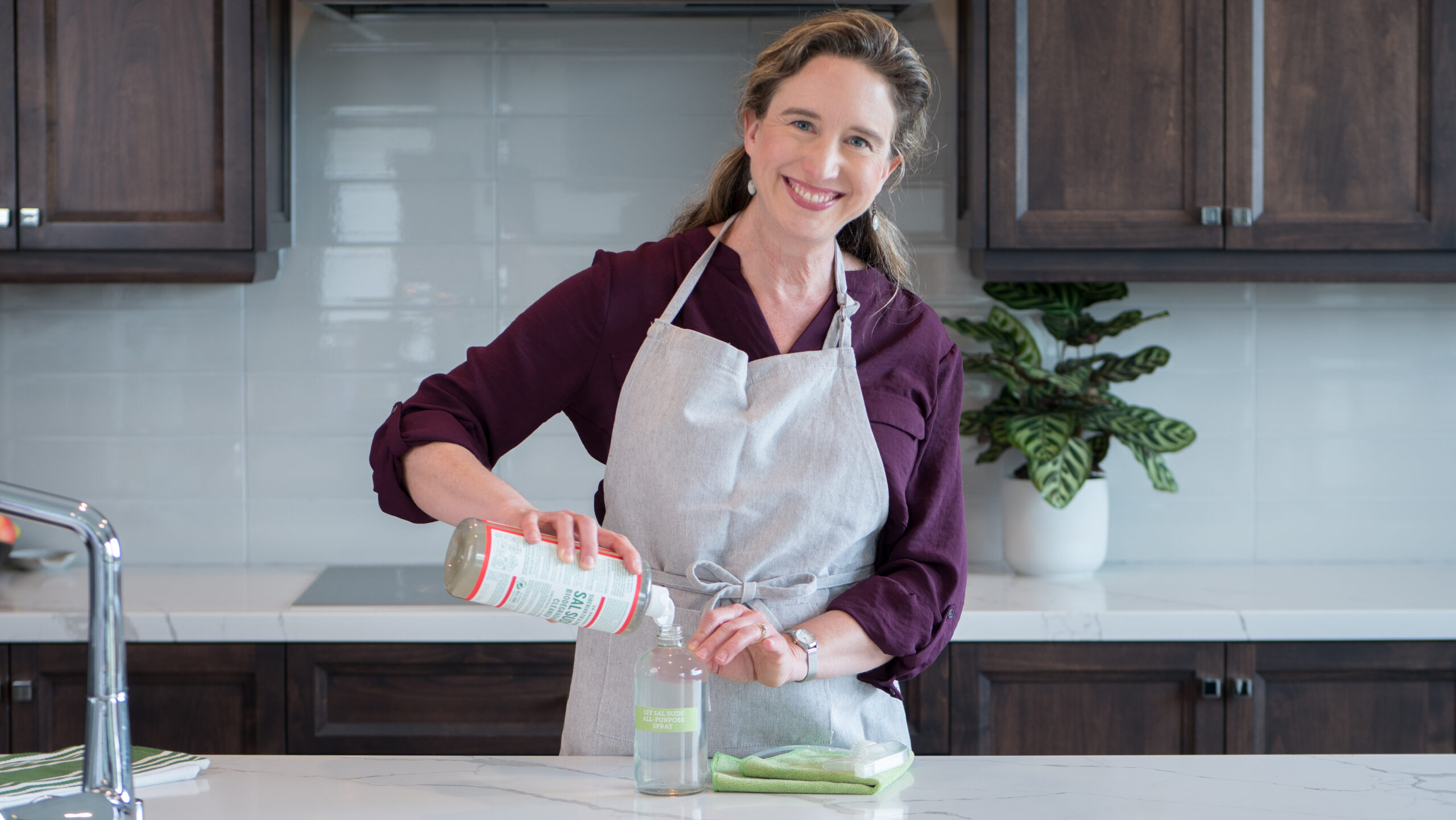 Lisa making GIY All-Purpose Spray at the kitchen counter.