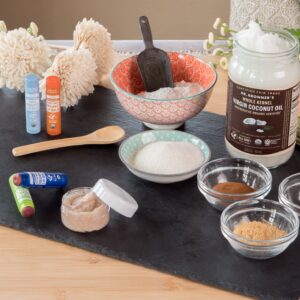 Ingredients for making a lip scrub & lip tint with Dr. Bronner's laid out on a table