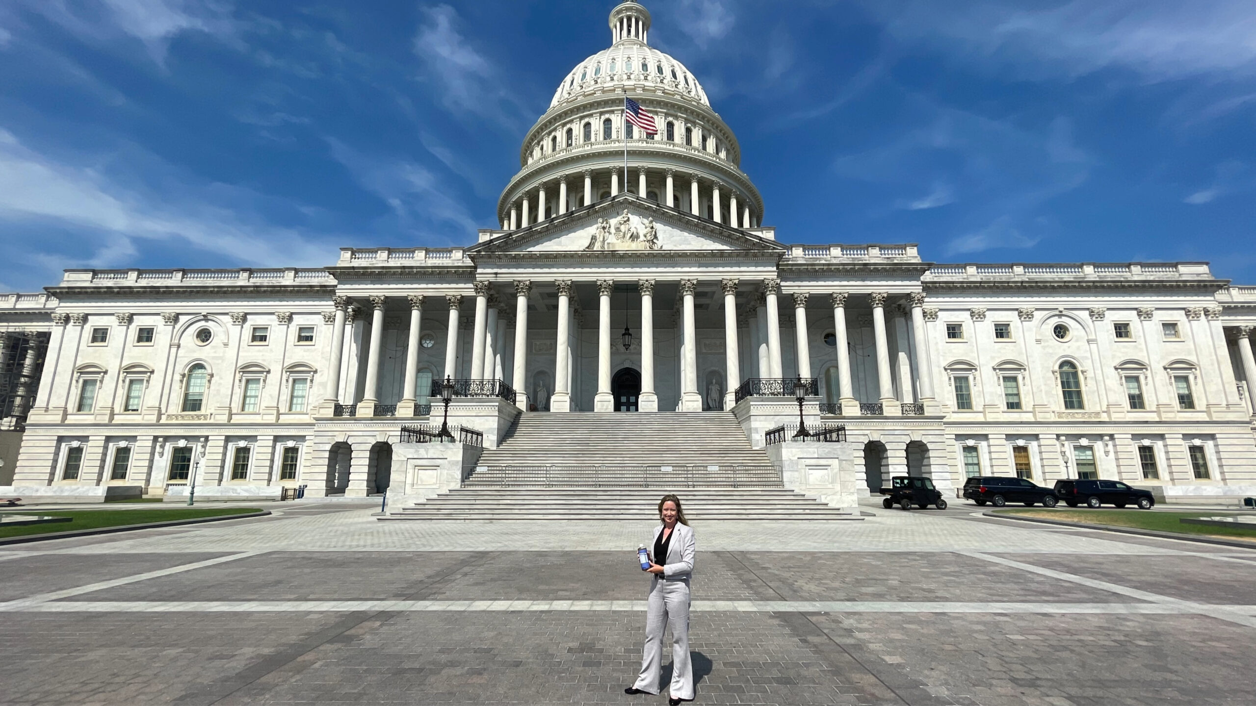 Lisa Bronner standing in the foreground of the picture with the large capitol building behind her.