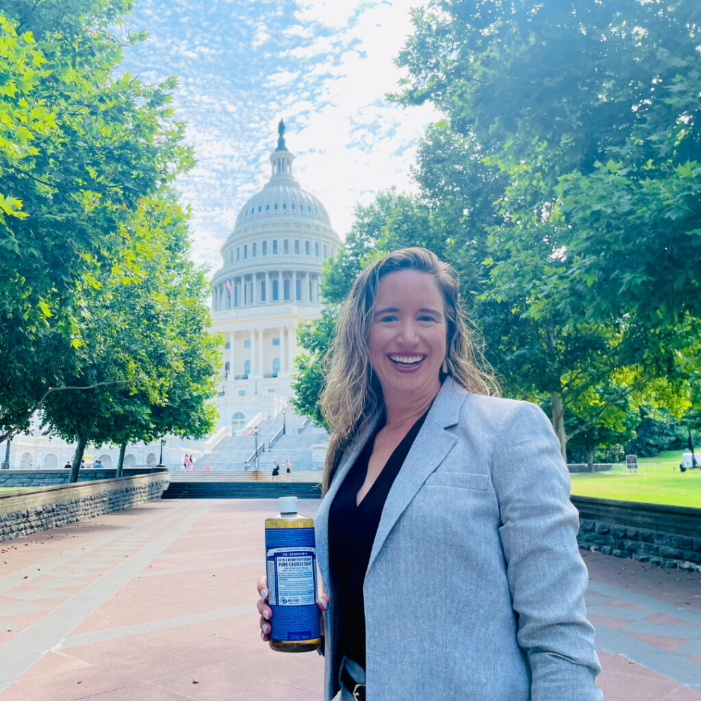 Lisa Bronner in the foreground, smiling in front of the capitol building in the distance behind her.