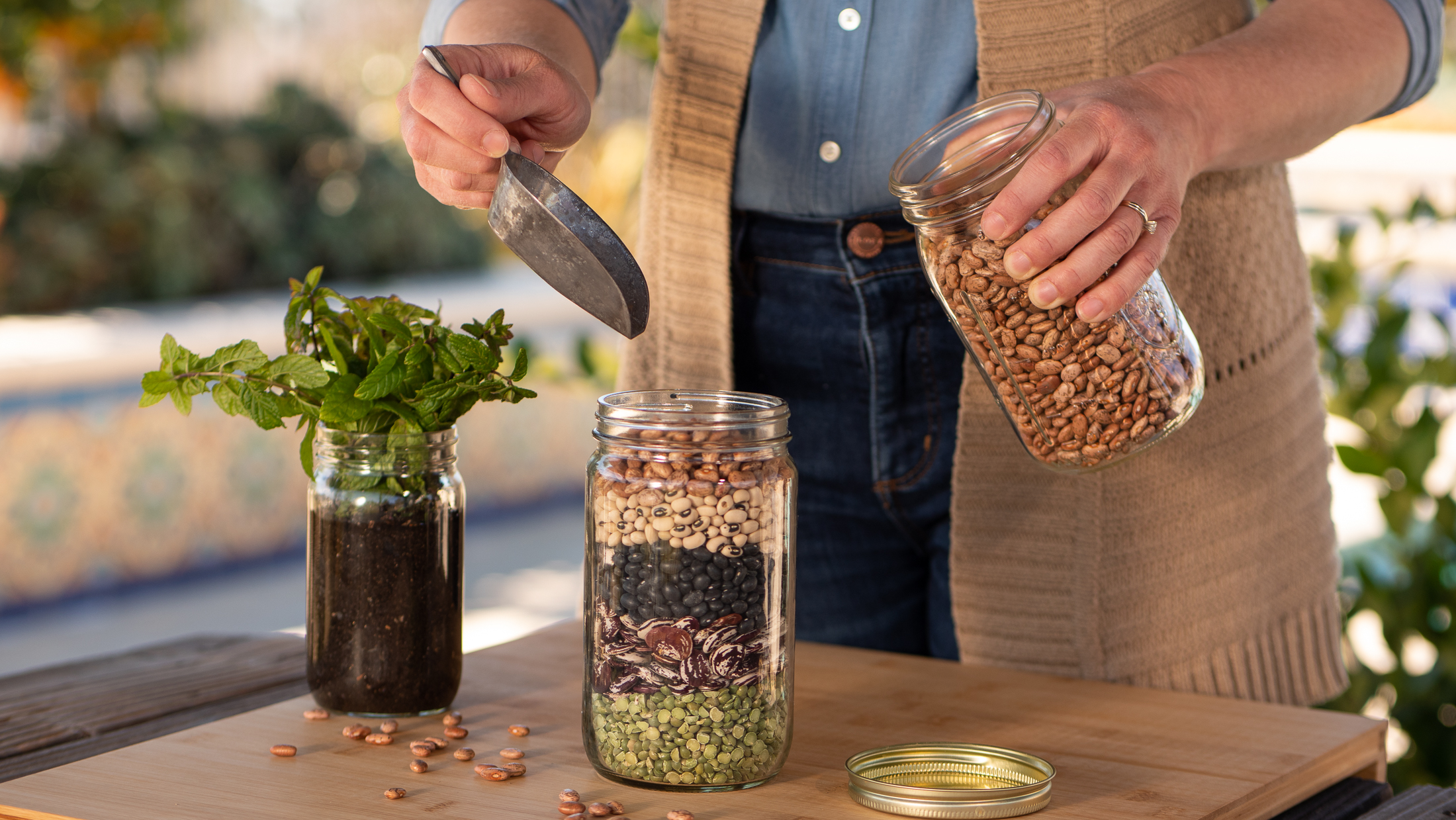 Person filling jar with dry beans.