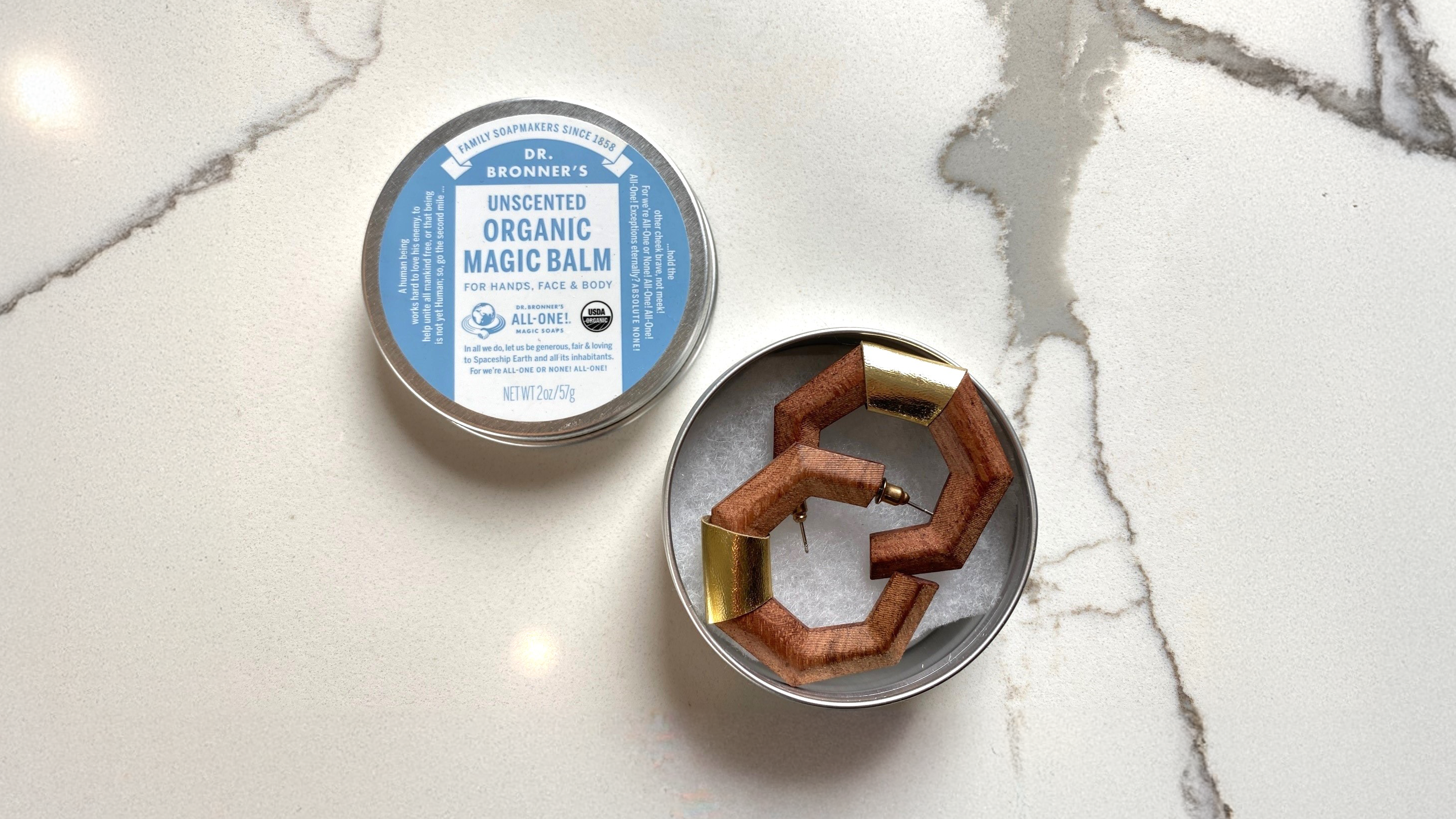 Magic Balm tin with earrings in it.